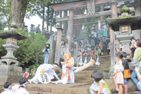 湯沢神社の鳥居前では猿田彦命の松明を持った勇壮な舞いが
