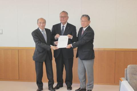 飯山市第6次総合計画基本構想素案を答申した坪根審議会長(中央)