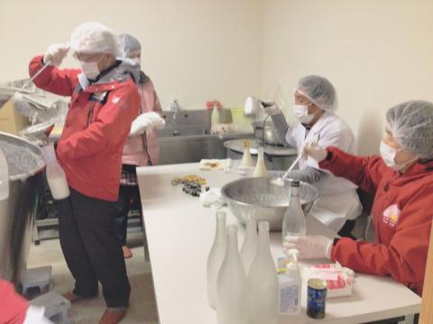 かまくら応援隊などの協力でびん詰め作業が進む