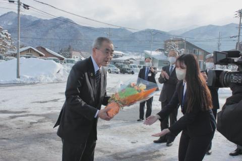 村の女性職員から花束を贈られ初登庁する日台村長