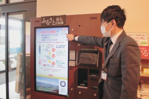農産物直売所の一画に設置された自販機を説明する市職員