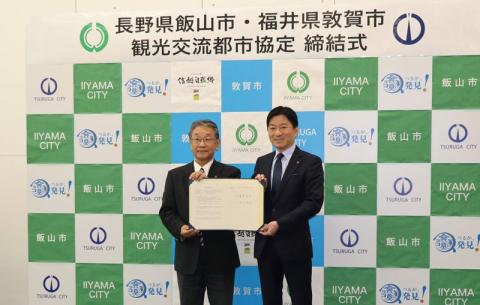 敦賀市役所で敦賀市・飯山市長が協定書に署名を交わして
