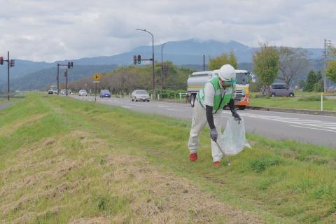 国道沿いの緑地でゴミを拾う参加者。観光客を気持ちよくーの思いが…