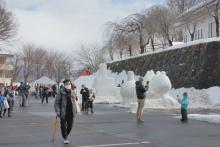 飯山城址公園弓道場下の大型雪像会場には人の流れが絶えず