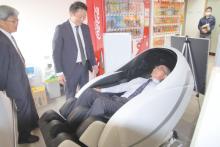 村役場ロビーに設置された「あんま王Ⅳ」を体験する日台村長