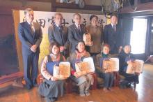 副賞の木島平村産の米を膝に入賞者らの記念写真が…